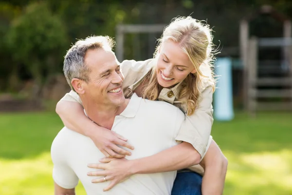 Husband giving piggy back to wife — Stock Photo, Image