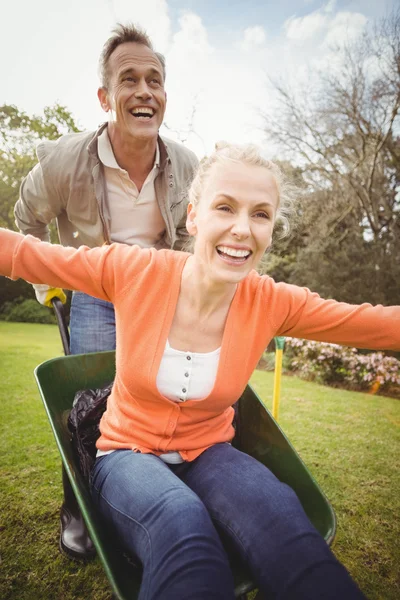 Esposo empujando esposa en una carretilla — Foto de Stock