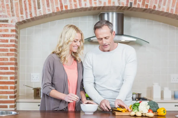 Cute couple slicing vegetables — Stock Photo, Image