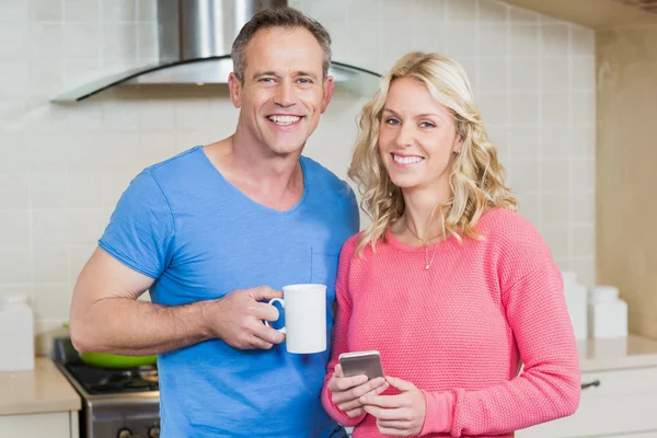 Bonito casal tomando café e olhando para o smartphone — Fotografia de Stock