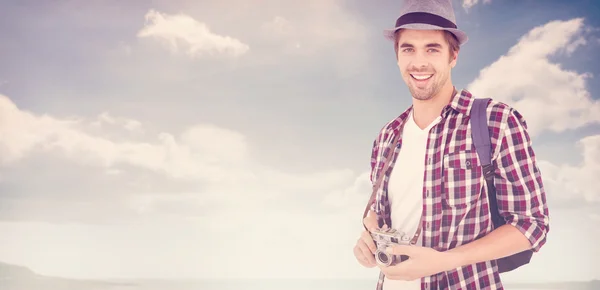 Hombre sonriendo mientras sostiene la cámara — Foto de Stock