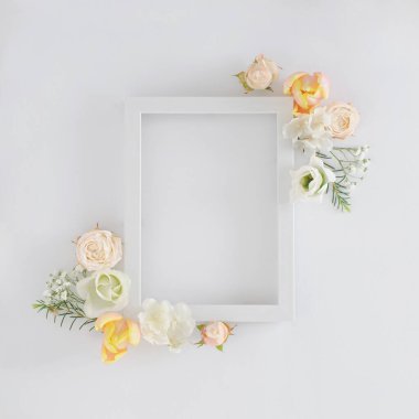 Renkli bahar çiçekleri ve beyaz arkaplan üzerine beyaz çerçeve ile yapılmış yaratıcı bir düzen. Minimum yassı tatil konsepti.