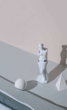 Antik bir Venüs heykeli ve pastel gri güneş ışığı arka planında geometrik şekiller olan soyut bir düzen. Sanatı minimalist bir estetik ile kavra. Retrofuturizm.