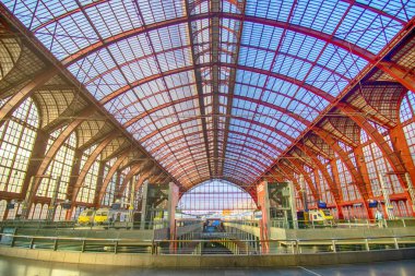 Antwerp Merkez İstasyonu 'nda kırmızı renkli metal kemer, platform ve trenlerle iniş sahnesi, Antwerp, Belçika - 09 - Haziran 2024