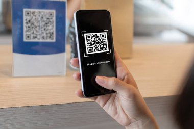 Kafe, restoran, dijital ödeme, ağ güvenliği, çevrimiçi alışveriş, paket yemek, internet teknolojisi konsepti için dijital cep telefonu taraması QR kod ödemesi kullanan bir müşteri