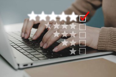 İş kadını el bilgisayarı üzerinde çalışıyor. Grafik işaretleme ile işaretleme kutusu üzerinde 5 yıldız puanı iyi derecelendirme, dijital pazarlama, kontrol listesi planlaması, iyi deneyim, müşteri geribildirim kavramı gözden geçirmek için çalışıyor.