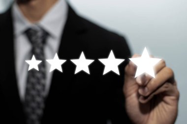 5 yıldız puanı. İş adamı müşteri eli iyi derecelendirme, dijital pazarlama, iyi deneyim, pozitif düşünme ve müşteri geri bildirim kavramını gözden geçirmek için görsel ekranda beş yıldız tuşuna basıyor