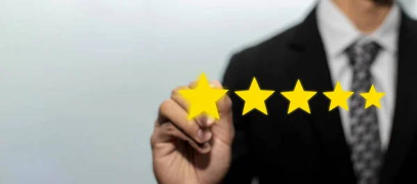 Yüksek kalite. İş adamı müşteri eli iyi derecelendirme, dijital pazarlama, iyi deneyim, pozitif düşünme ve müşteri geri bildirim kavramını gözden geçirmek için görsel ekranda beş yıldız tuşuna basıyor