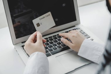 Kadın eli şifre kodunu ev ofisinin, internetin, dijital pazarlamanın, çevrimiçi alışverişin, çevrimiçi ödemenin ve dijital teknoloji konseptinin kredi kartıyla ödeyen dizüstü bilgisayara giriyor.