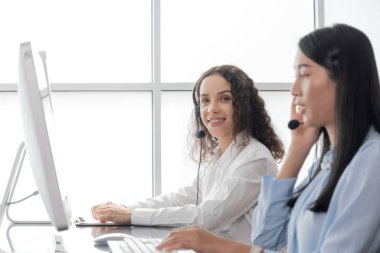 Yardım hattı. Ofiste çalışan, kulaklıklı, online pazarlama, müşteri destek servisi, çağrı merkezi, telefon operatörü, video çağrı konsepti olan mutlu, genç beyaz kadın çağrı merkezi müşteri destek yöneticisi.