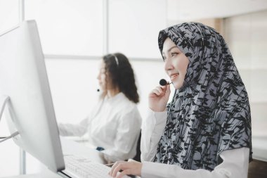 Mutlu Müslüman kadın tesettür çağrı merkezi müşteri destek yöneticisi ofiste çalışıyor, eğitim online, müşteri destek servisi, çağrı merkezi, telefon operatörü, video konsepti