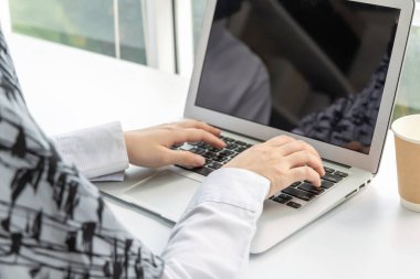 Müslüman kadın el bilgisayarı üzerinde çalışıyor ev ofisinin masasında, evden çalışıyor, arama ağı, sosyal ağ, çevrimiçi, iş stratejisi, finans, yatırım ve dijital teknoloji kavramı