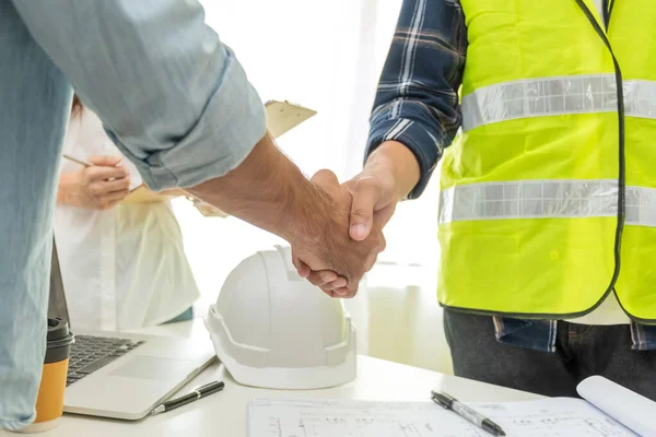 İş toplantısından sonra müteahhit el sıkışması inşaat şantiyesi inşaatı, iş ortaklığı, mühendislik, iş birliği ve takım çalışması kavramında proje sözleşmesi başlat