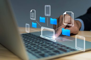 Belge Yönetim Sistemi. İş adamı dizüstü bilgisayarda, yapay zekada, dosya transferinde, bulut hesaplama teknolojisi kavramında otomasyon yazılımı yönetici dosya dizini kullanıyor.