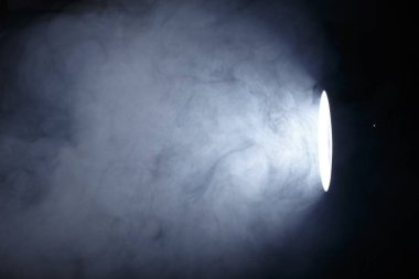 El feneri ya da dumanın içindeki spot ışığı. Karanlık bir arkaplanda ışık huzmesi. Sis