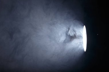 El feneri ya da dumanın içindeki spot ışığı. Karanlık bir arkaplanda ışık huzmesi. Sis