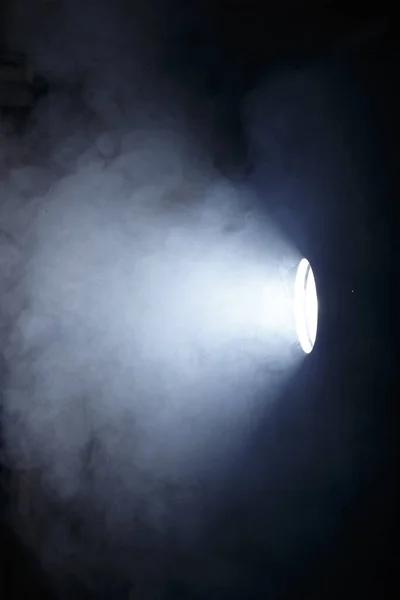 El feneri ya da dumanın içindeki spot ışığı. Karanlık bir arkaplanda ışık huzmesi. Sis