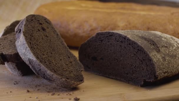 Μαύρο Ψωμί Βρίσκεται Ένα Ξύλο Κοπής Μαζί Ένα Καρβέλι Λευκό — Αρχείο Βίντεο