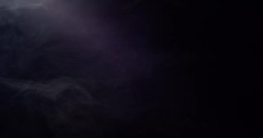 Projektörün titreyen ışığında duman bulutları yavaşça havaya karışıyor.