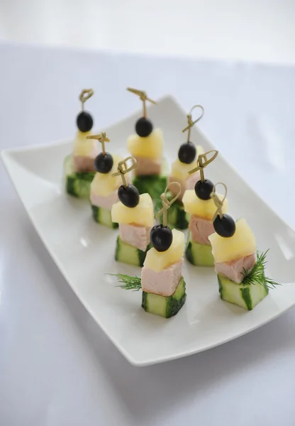 Petites canapés avec jambon sur une brochette Images De Stock Libres De Droits