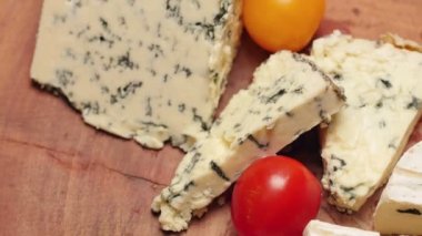 Çeşit peynir otlar ve ahşap oyun tahtası, karabiber ile döner