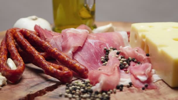Närbild på tunna skivor prosciutto med torr rå korvar och schweizisk ost på trä skärbräda — Stockvideo