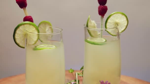 Dois copos de limonada com limão e framboesa, girando — Vídeo de Stock