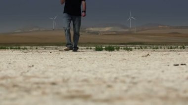 Alev alev yanan güneşin altında kurutulmuş Tuz Gölü üzerinde yürüyen adam