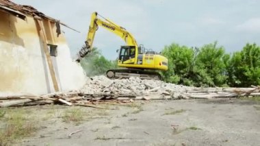 DOBROGEA, ROMANIA - 12 Mayıs: 12 Mayıs 2021 'de Romanya' nın Dobrogea kentinde eski binaları yıkan kazı aracı tespit edildi