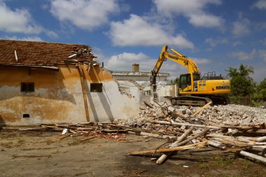 DOBROGEA, ROMANIA - 12 Mayıs: 12 Mayıs 2021 'de Romanya' nın Dobrogea kentinde eski binaları yıkan kazı aracı tespit edildi