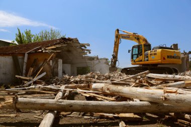 DOBROGEA, ROMANIA - 12 Mayıs: 12 Mayıs 2021 'de Romanya' nın Dobrogea kentinde eski binaları yıkan kazı aracı tespit edildi