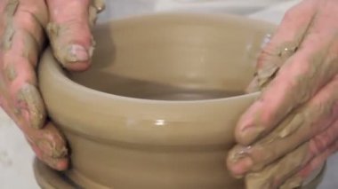 Çömlekçinin tekil tekerleğinde şekilolan eller