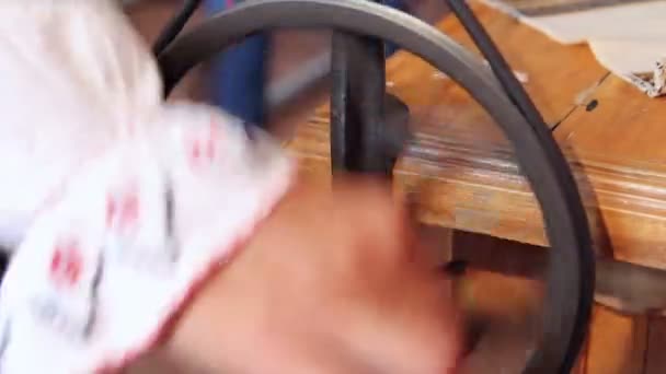 Woman using an antique winder for wrapping yarn onto a spool — Stock Video