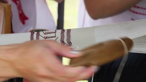 Mãos de uma mulher tecendo em um velho tear de madeira — Vídeo de Stock