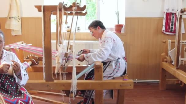 一个女人编织在一个古老的木制织机，稳定的镜头拍摄与娃娃 — 图库视频影像