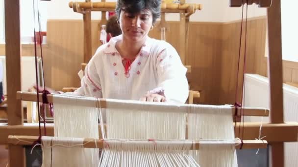 Bir kadın eski bir tahta dokuma tezgahında dokuma — Stok video