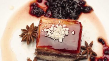 Yakın bir karamelli pasta beyaz beyaz tabağında, çikolata ile döner