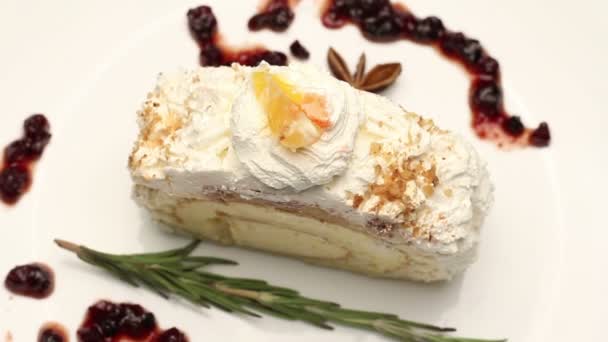 Торт со взбитыми сливками на белой тарелке, вращающийся — стоковое видео