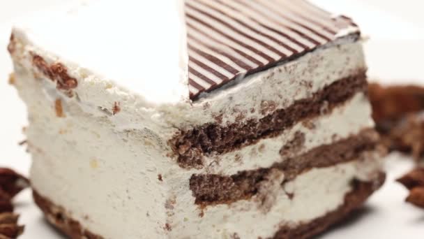 Close up of a cake with whipped cream and star anise on white plate, rotating — Stock Video