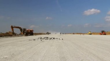 Zaman atlamalı bir Havaalanı pist üzerinde çalışan ağır inşaat ekipmanları