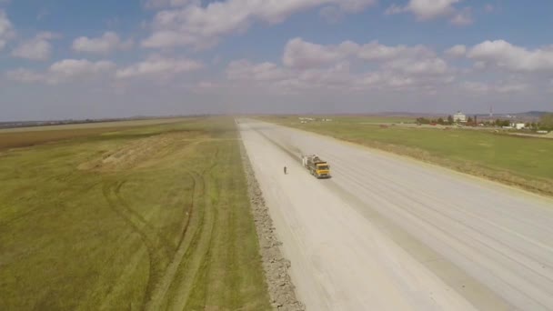 Attrezzature da costruzione pesanti che lavorano su una pista aeroportuale, vista aerea — Video Stock