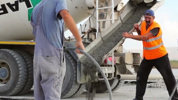 Cement vrachtwagen gieten cement in een start-en landingsbaan constructie — Stockvideo