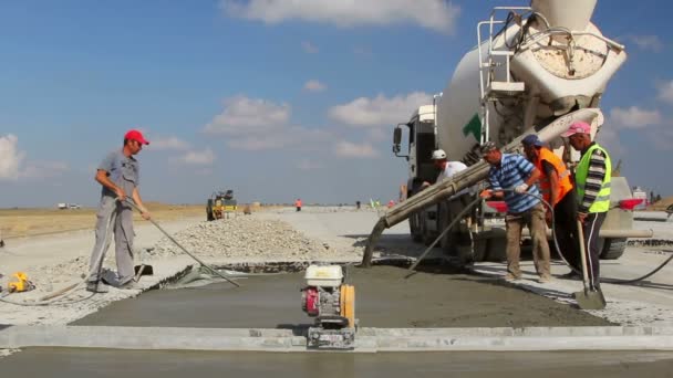 Cement vrachtwagen gieten cement in een start-en landingsbaan constructie — Stockvideo