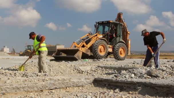 활주로 건설 현장에 삽질 하는 근로자 — 비디오