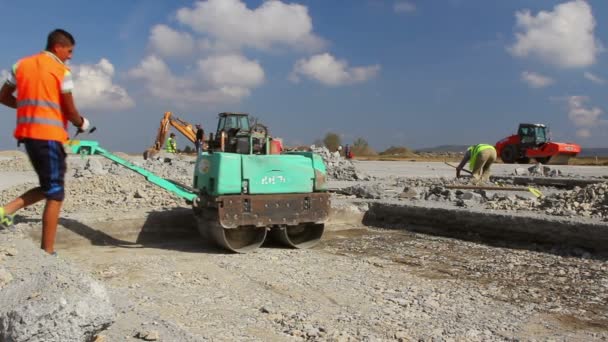 Trabajador de la construcción compactando el suelo en una pista de construcción — Vídeos de Stock