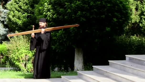 Christlicher Mönch schlägt mit kleinem Holzhammer auf ein großes Holzstück (Toaca) ein, um die Atemlosen zum Gebet aufzufordern — Stockvideo