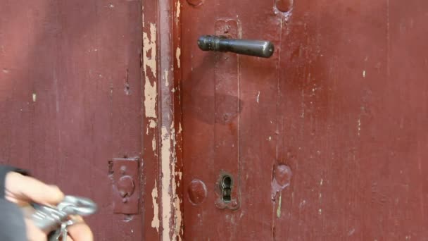 Man opens an old wooden door with a huge iron key — Stock Video