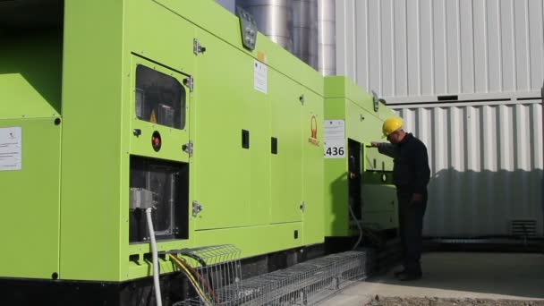 Worker who operates two powerful diesel generators that supply an asphalt mixing plant — Stock Video