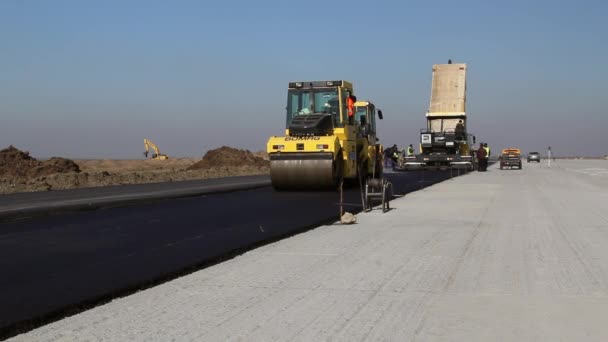 Rodillos de carretera nivelando pavimento de asfalto fresco — Vídeo de stock
