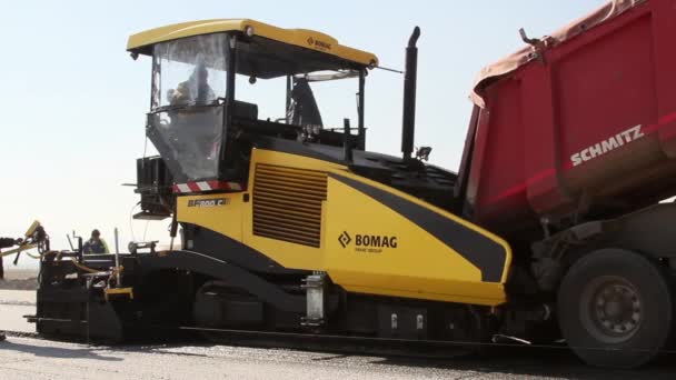 Tracked paver laying fresh asphalt pavement — Stock Video